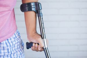 Image of a woman's arm holding a crutch to convey the need for Gait Training Manhasset NY
